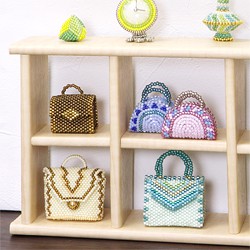 Miniature beaded bags displayed on a small shelf