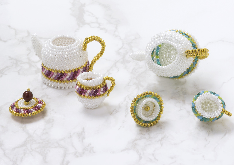 The lid of the beaded teapot can be opened.